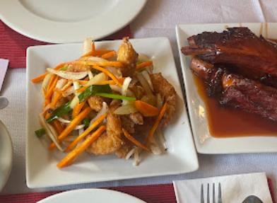 Salt and chilli style chicken with peppers next to barbecued spare ribs